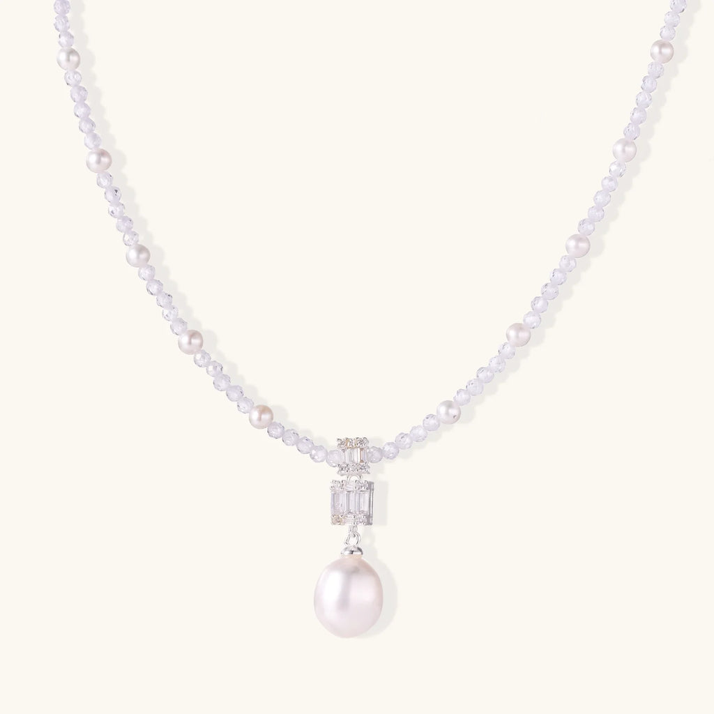 Dainty necklace with lavender crystal beads, freshwater pearls, geometric pendant, and large pearl drop on white background.