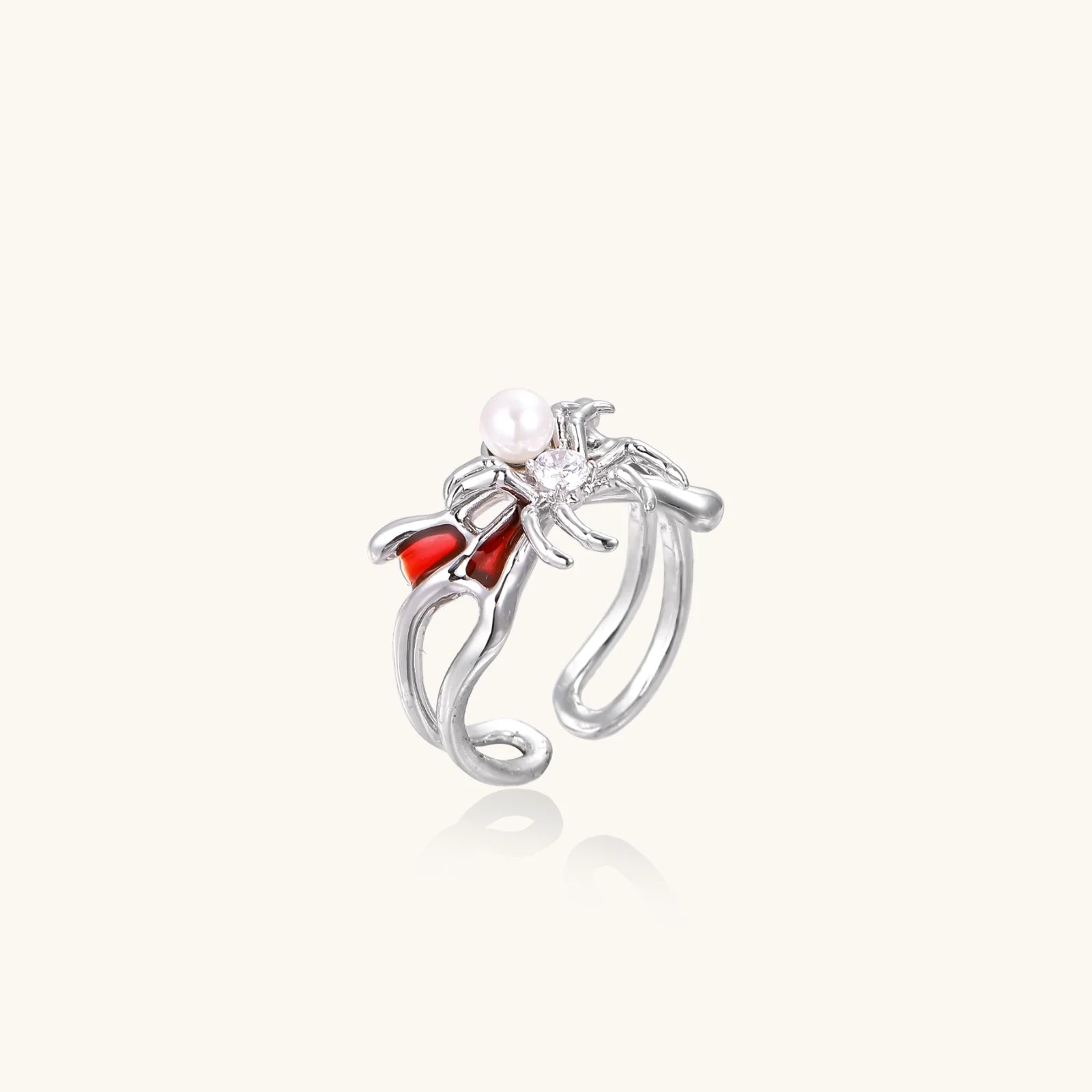 White gold plated spider ring with pearl body, clear zirconia center, and red enamel leg accents on adjustable band