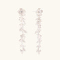 Long sterling silver drop earrings with delicate floral vine design and crystal accents on white background