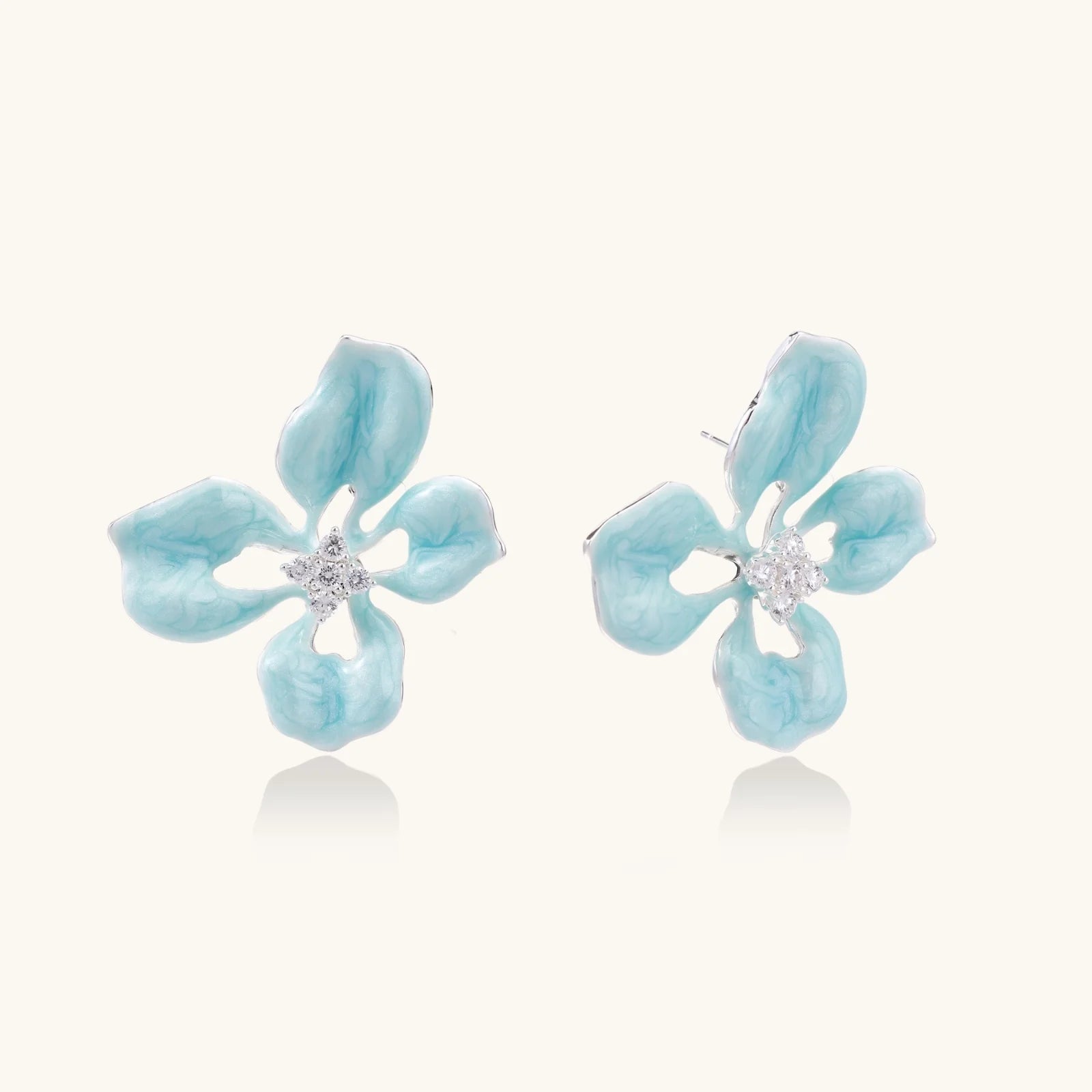 Turquoise enamel flower stud earrings with marbled finish and crystal centers on 18K gold plated brass