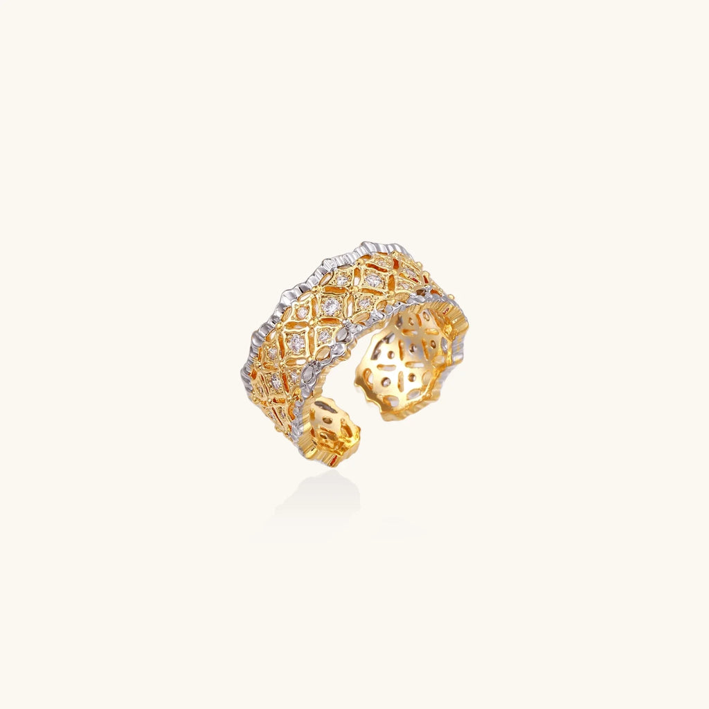 Two-tone ring with geometric lattice pattern in gold and silver finish with crystal accents on beige background