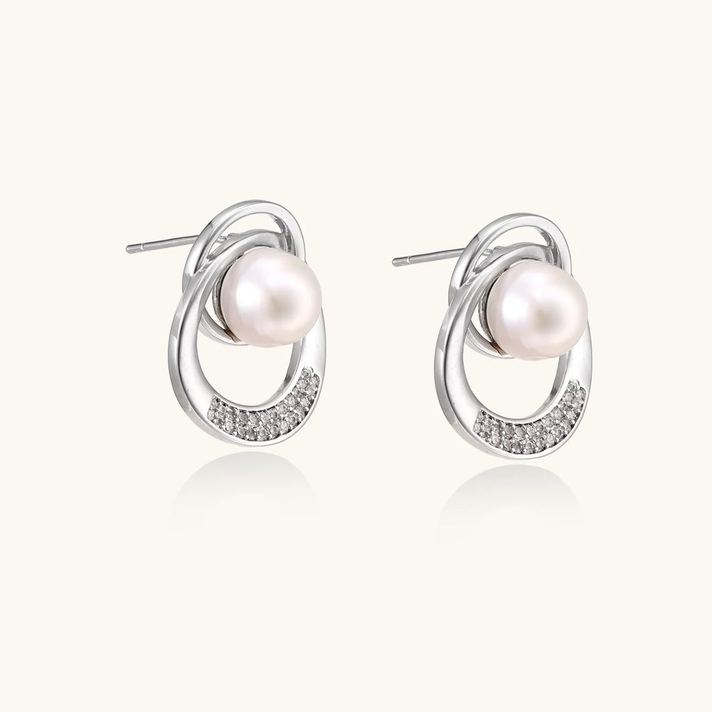 White gold-plated brass earrings with circular design, freshwater pearl center, and diamond accents
