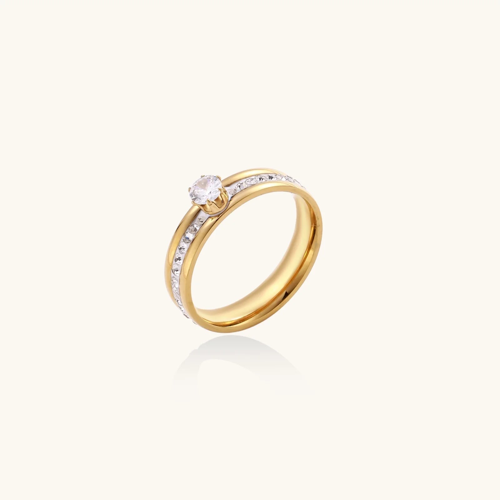 Gold-plated double-band ring with center rhinestone solitaire and channel-set stones on white background