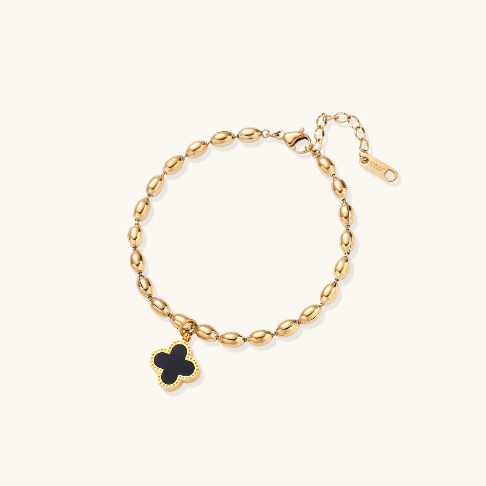 18K gold-plated oval bead chain bracelet with quatrefoil clover charm featuring mother of pearl inlay on cream background