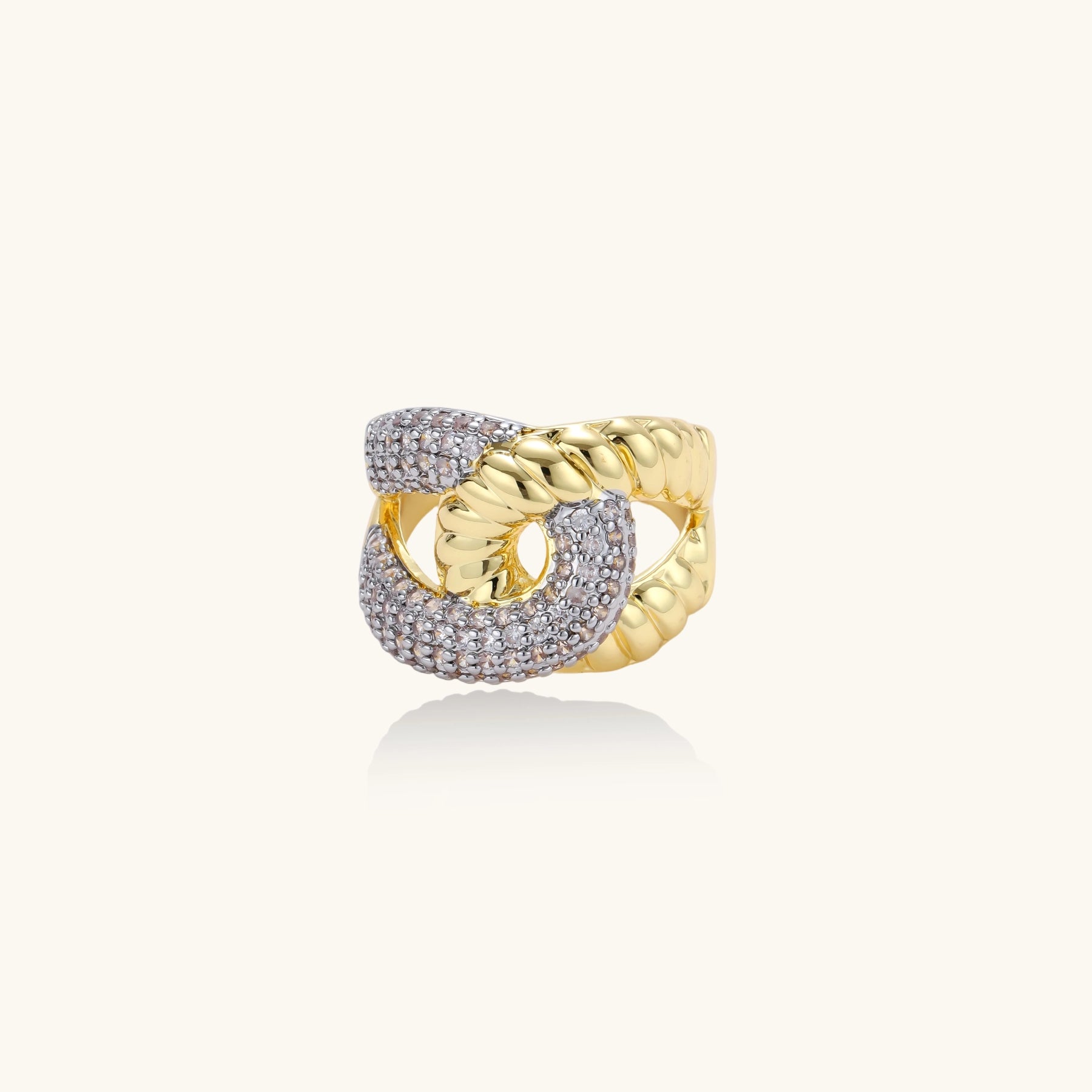 Chunky gold-plated chain-link ring with curved segments and sparkling zirconia crystals on neutral background